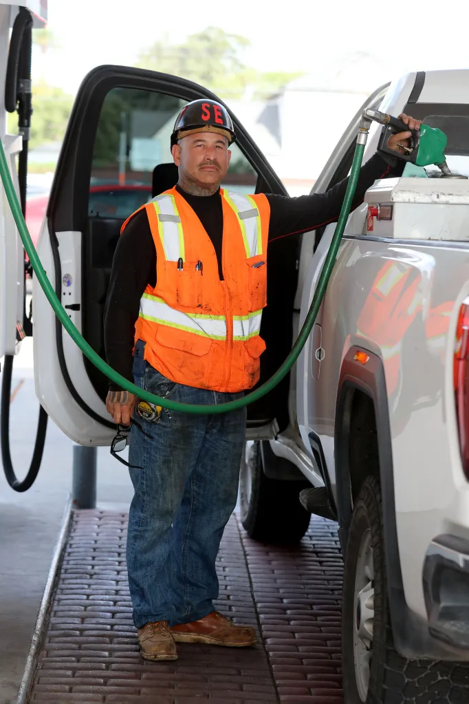Pipe fitter Nestor Luna fills his truck with diesel at a gas station.
