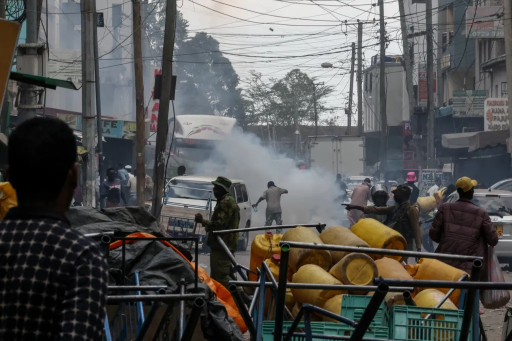 Police using tear gas to disperse a crowd at the site of a building collapse.