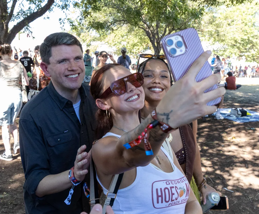 Politician James Talarico poses for a selfie with fans at a music festival.