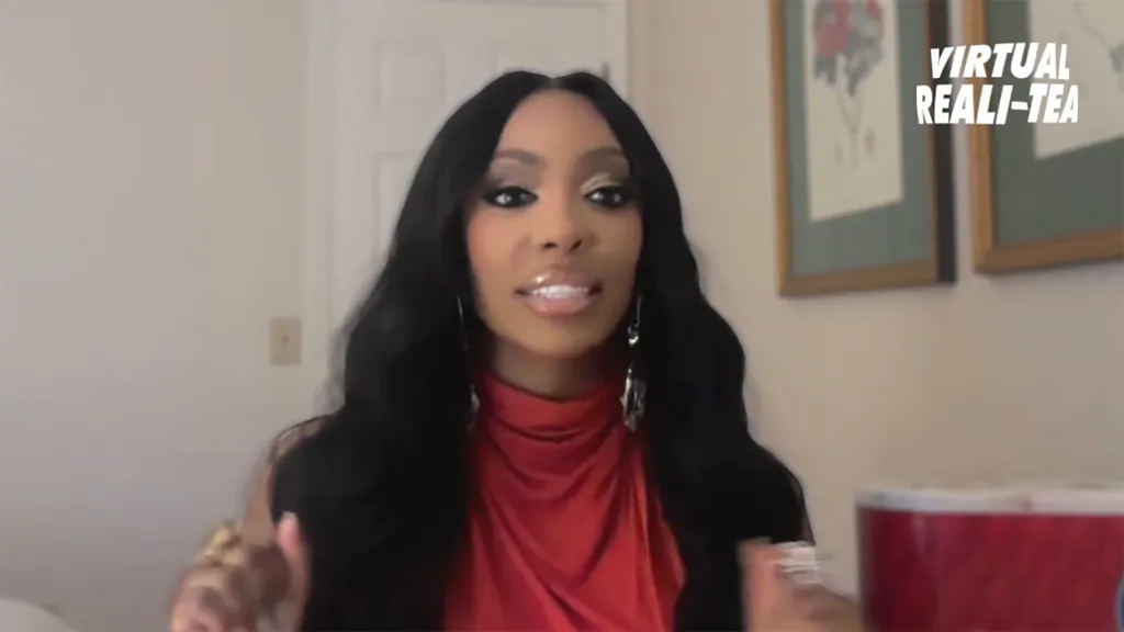 Porsha Williams in a video interview wearing a red top.