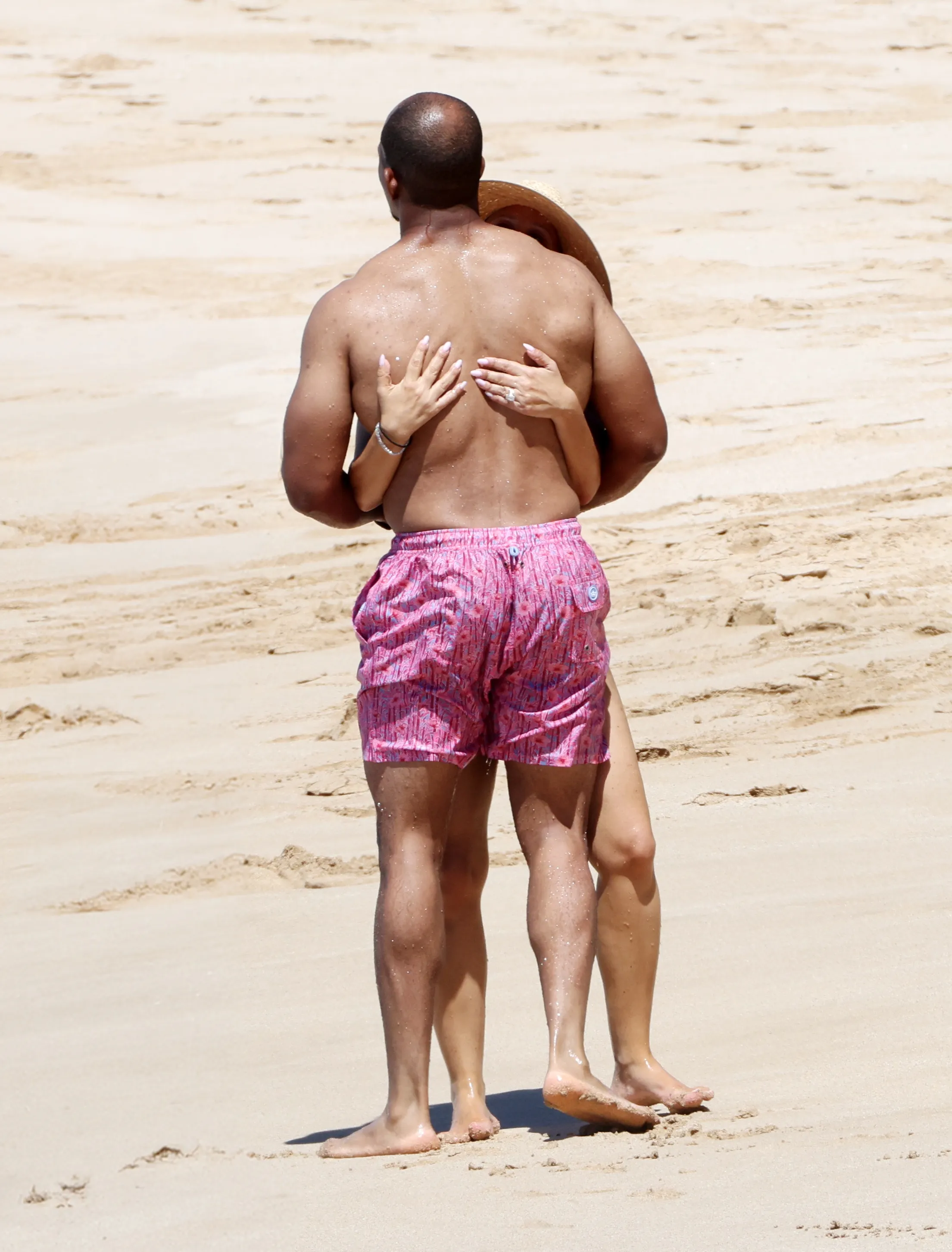 Jennifer Meyer and new husband Geoffrey Ogunlesi embrace and show off her massive wedding ring on a beach in Hawaii.