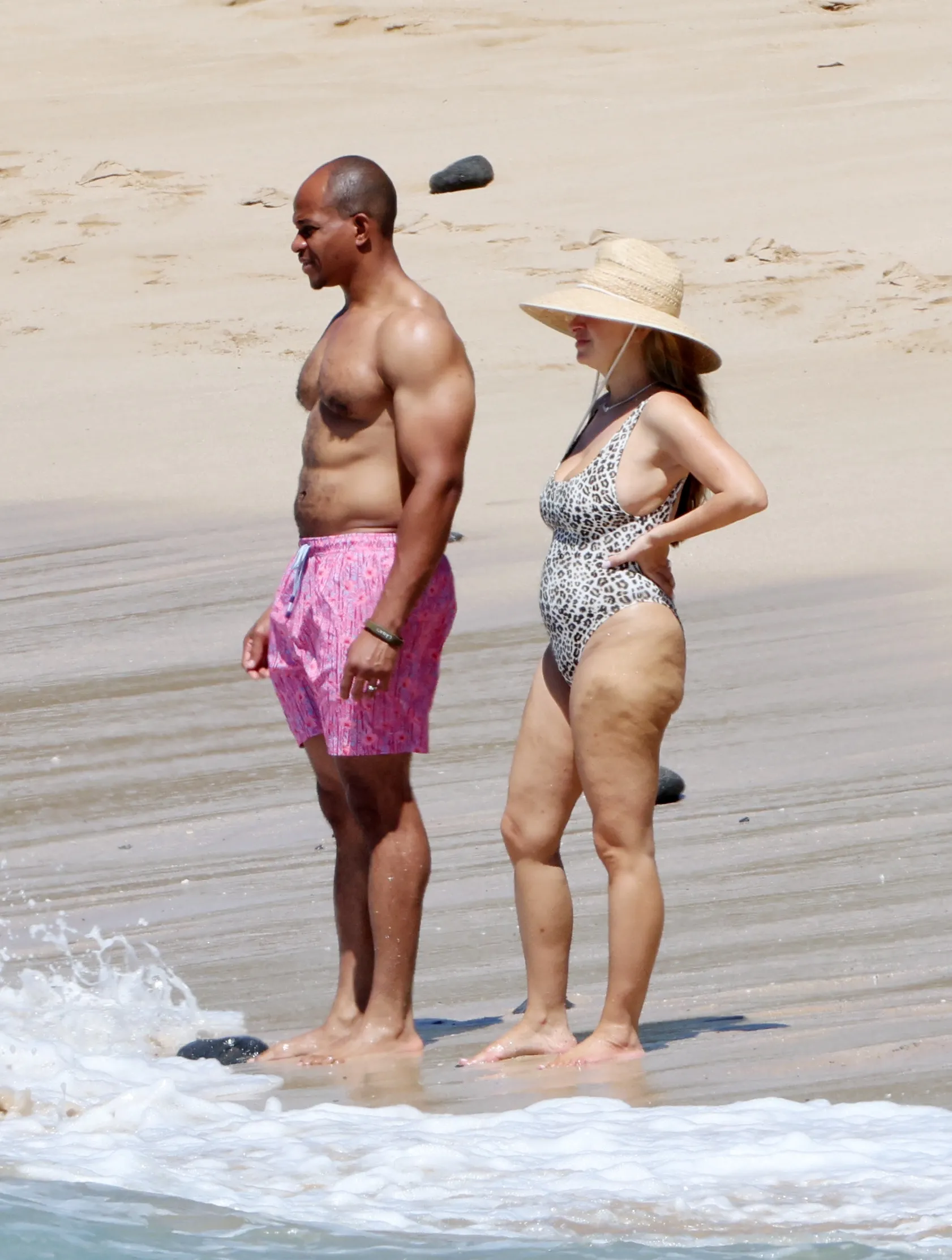 Jennifer Meyer and Geoffrey Ogunlesi stand on a beach in Hawaii.