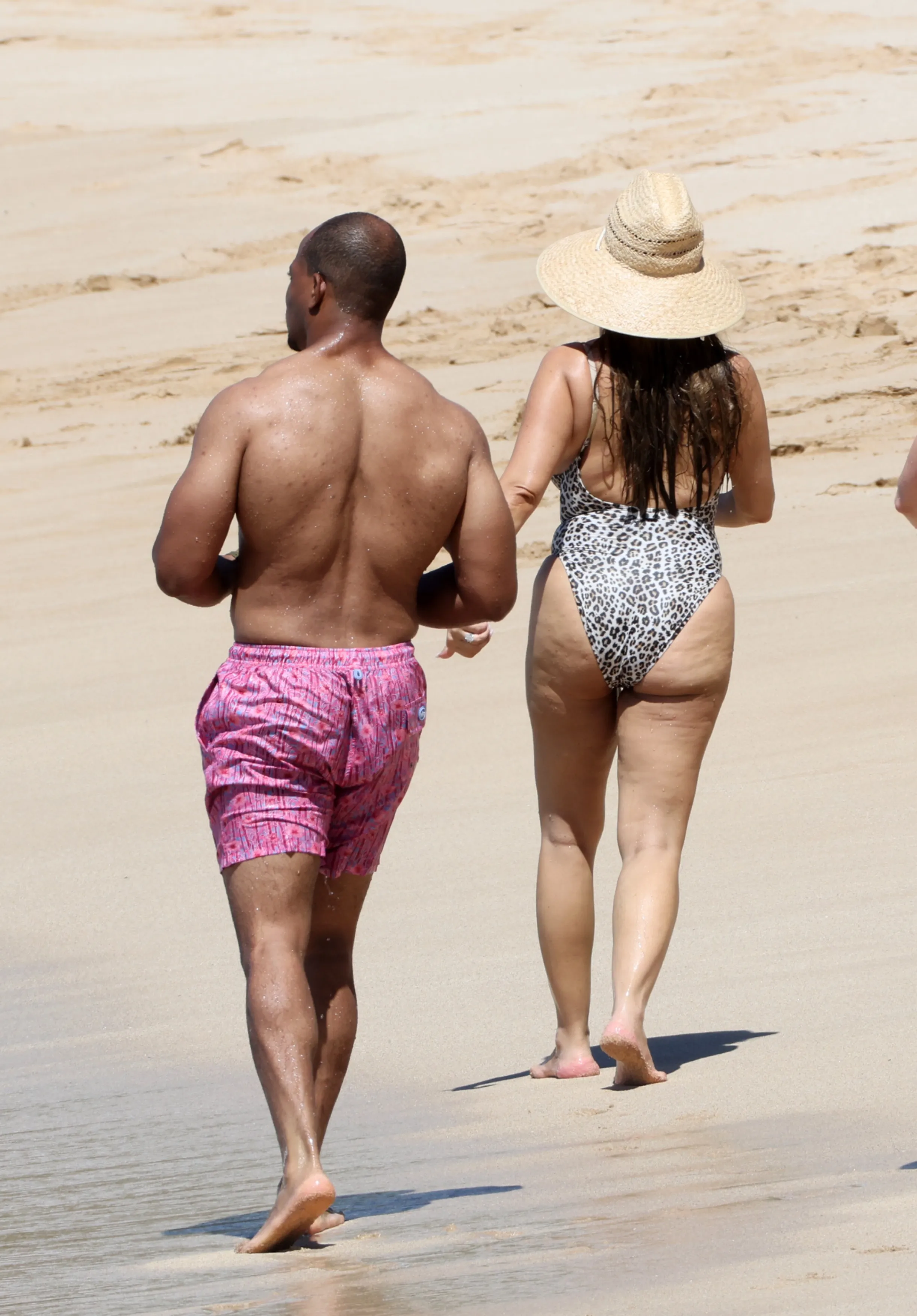 Jennifer Meyer and Geoffrey Ogunlesi strolling on a beach in Hawaii.