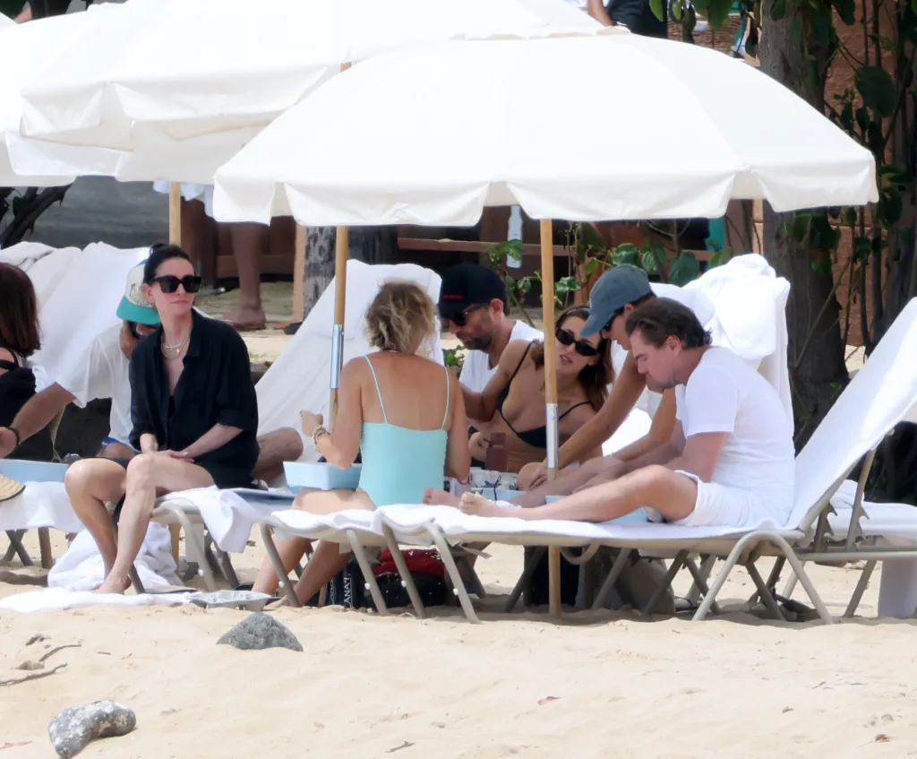 Courteney Cox and other guests relax under beach umbrellas in Hawaii.