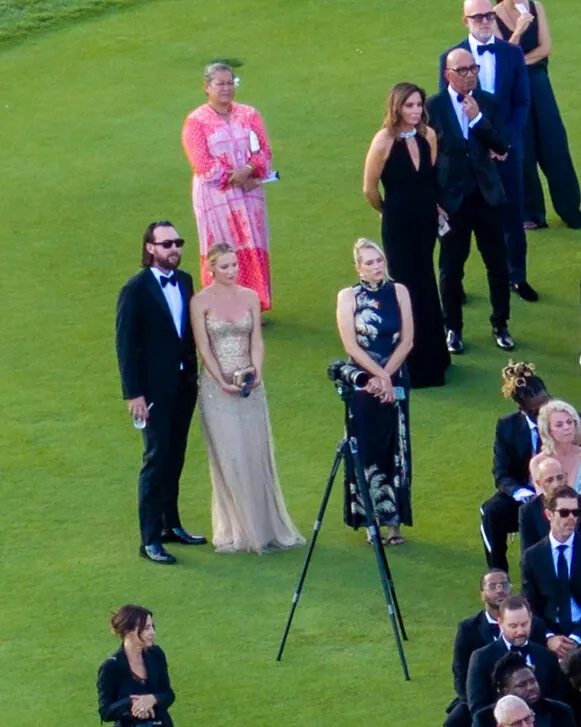 Kate Hudson and Danny Fujikawa standing on a lawn with other guests at an event.