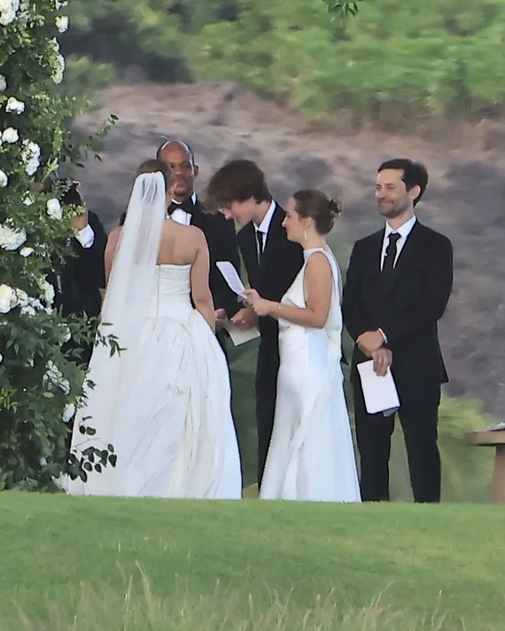 Jennifer Meyer, Geoff Ogunlesi, Tobey Maguire, Otis Maguire, and Ruby Maguire at a wedding ceremony outdoors.