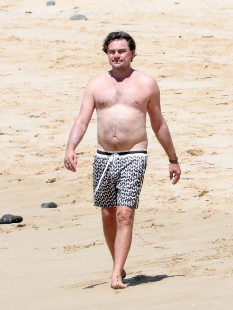Leonardo DiCaprio walking on a beach in Hawaii.