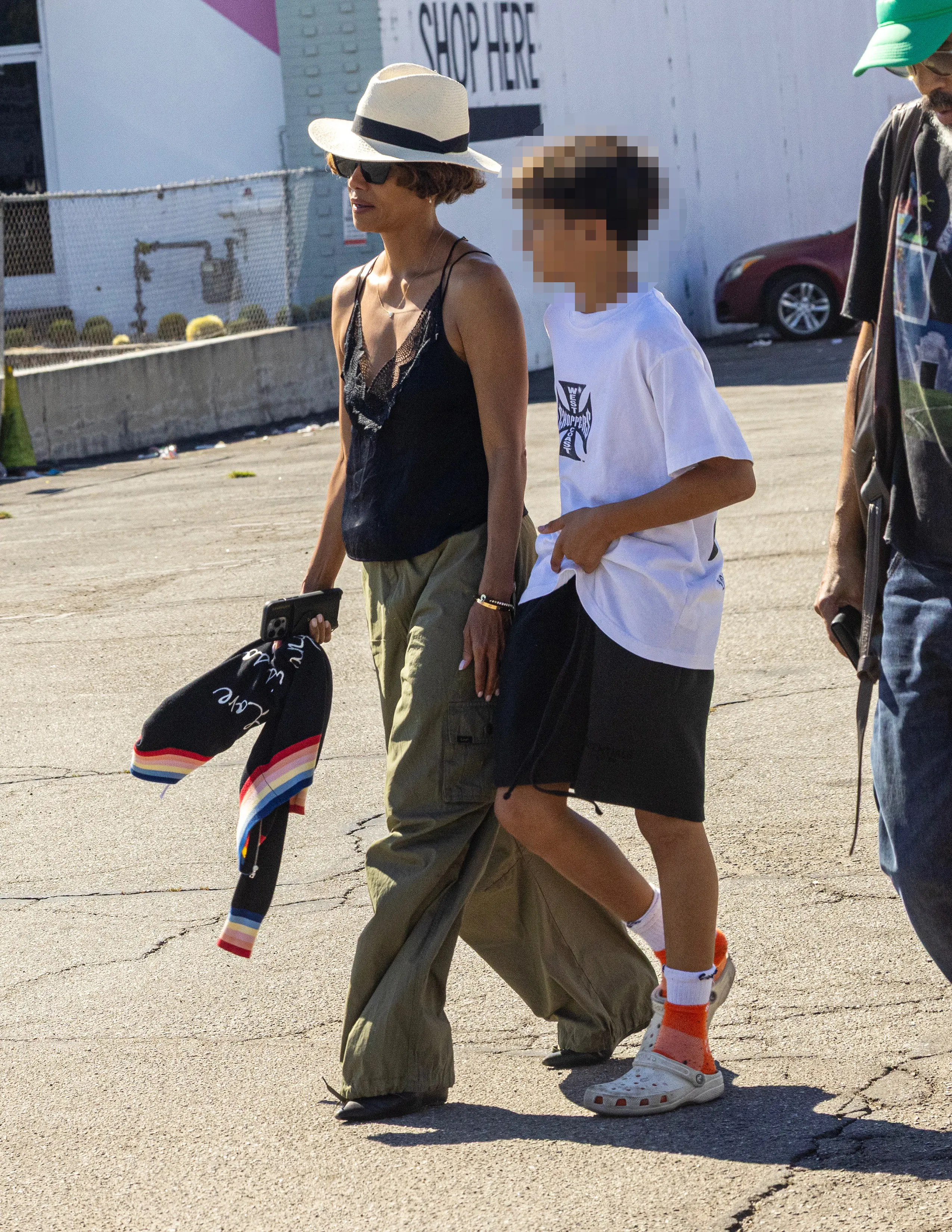 Halle Berry walking outdoors with her son Maceo and partner Van Hunt.