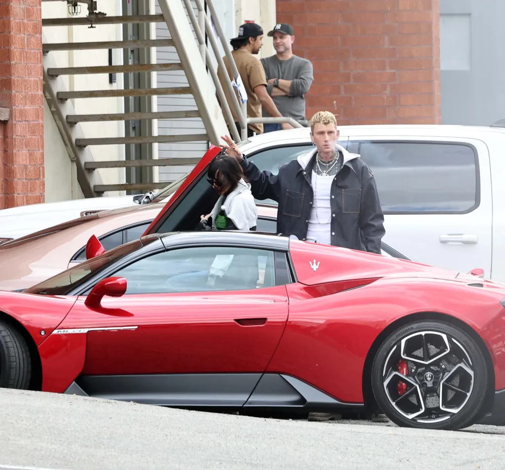 Dakota Johnson and Machine Gun Kelly getting into a red sports car outside a studio in Los Angeles.