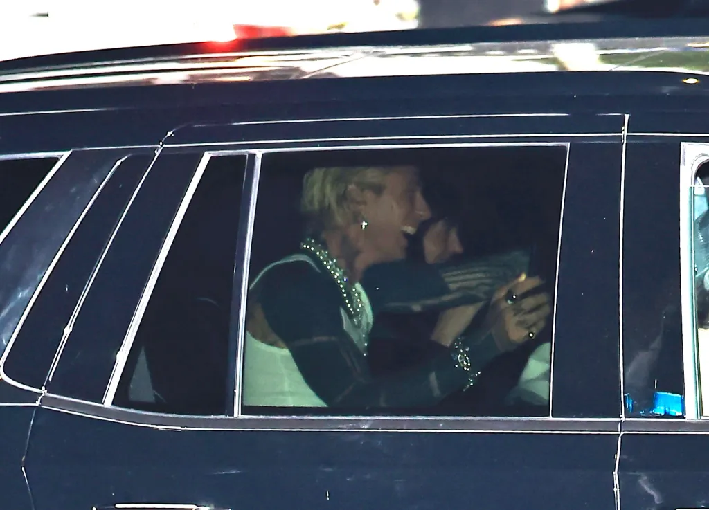 Machine Gun Kelly and Dakota Johnson sitting inside a black SUV.