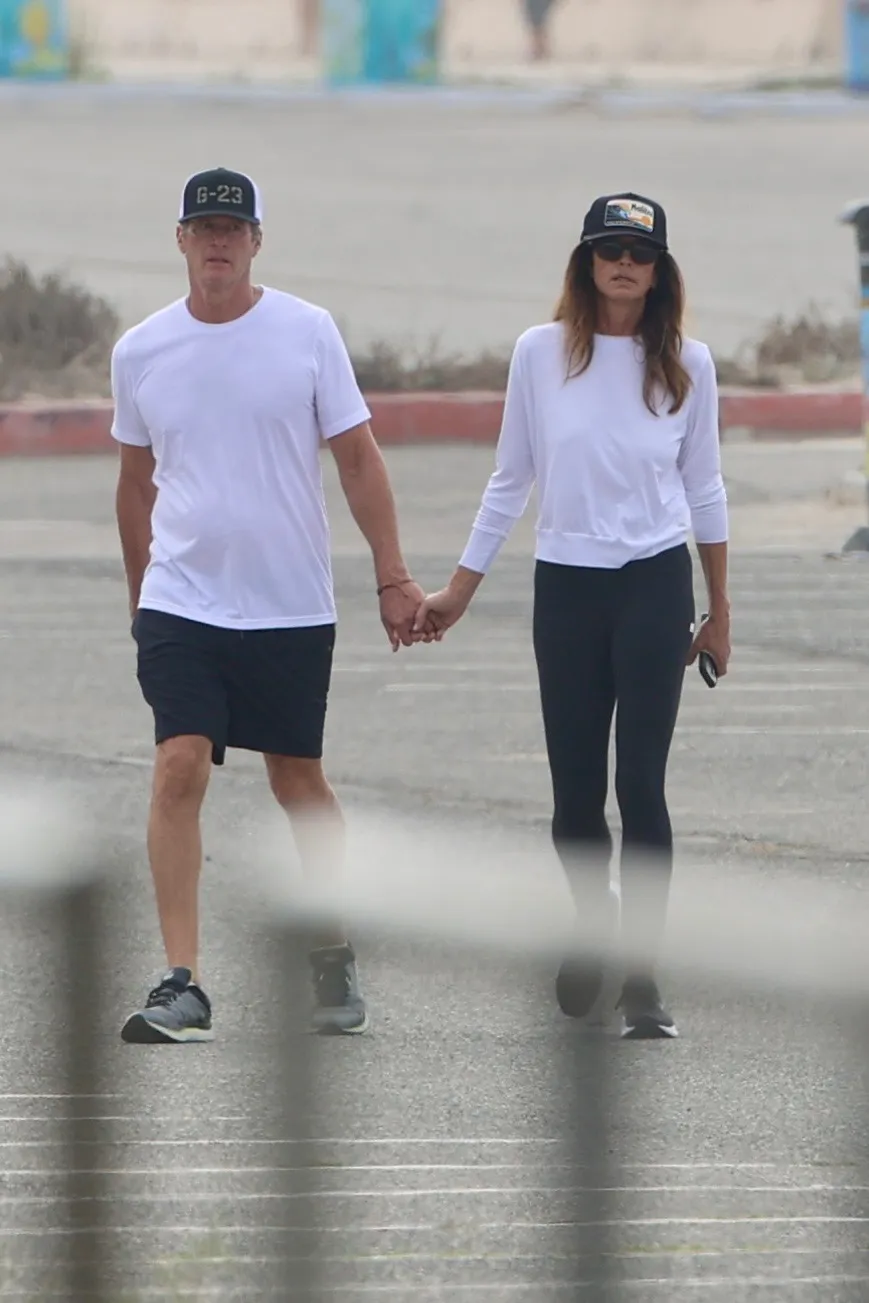 Cindy Crawford and Rande Gerber walk together hand-in-hand at Zuma Beach in Malibu.