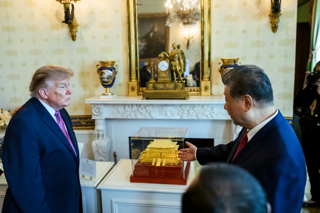 President Donald J. Trump and President Xi Jinping of China view a golden model in a glass case in the White House.