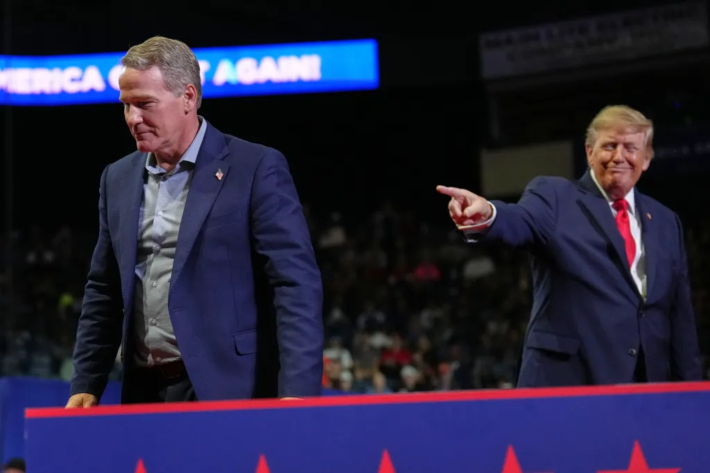 President Donald Trump gestures as Sen. Jon Husted stands on stage during a campaign rally.