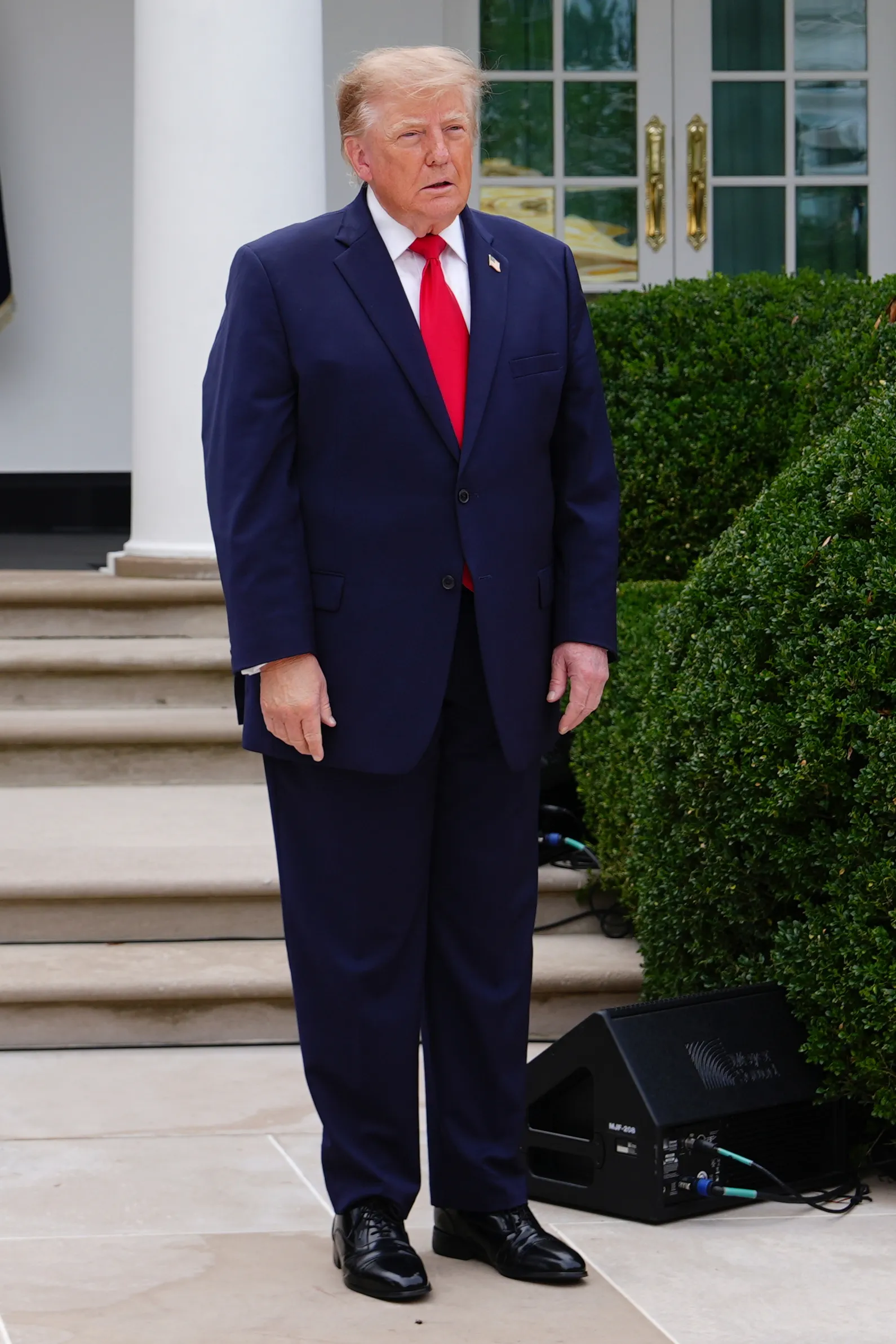 President Donald Trump stands outside the White House.