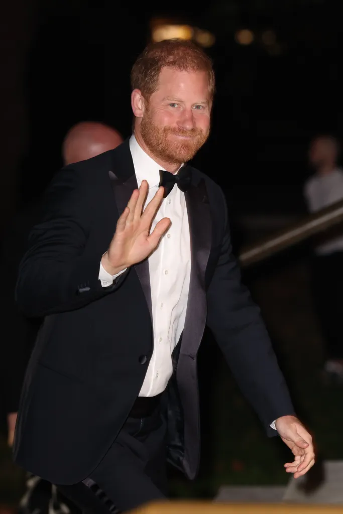 Prince Harry waving while arriving at a charity event in London.