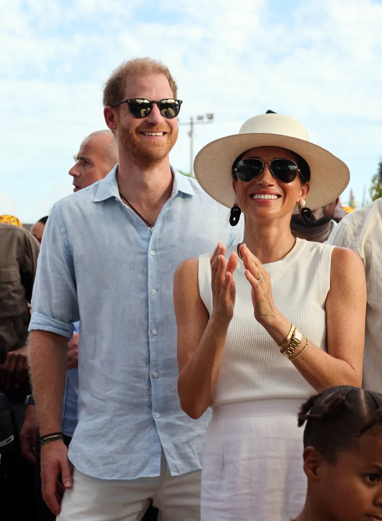 Prince Harry and Meghan, Duchess of Sussex, smile and clap during their visit to San Basilio de Palenque in Colombia.