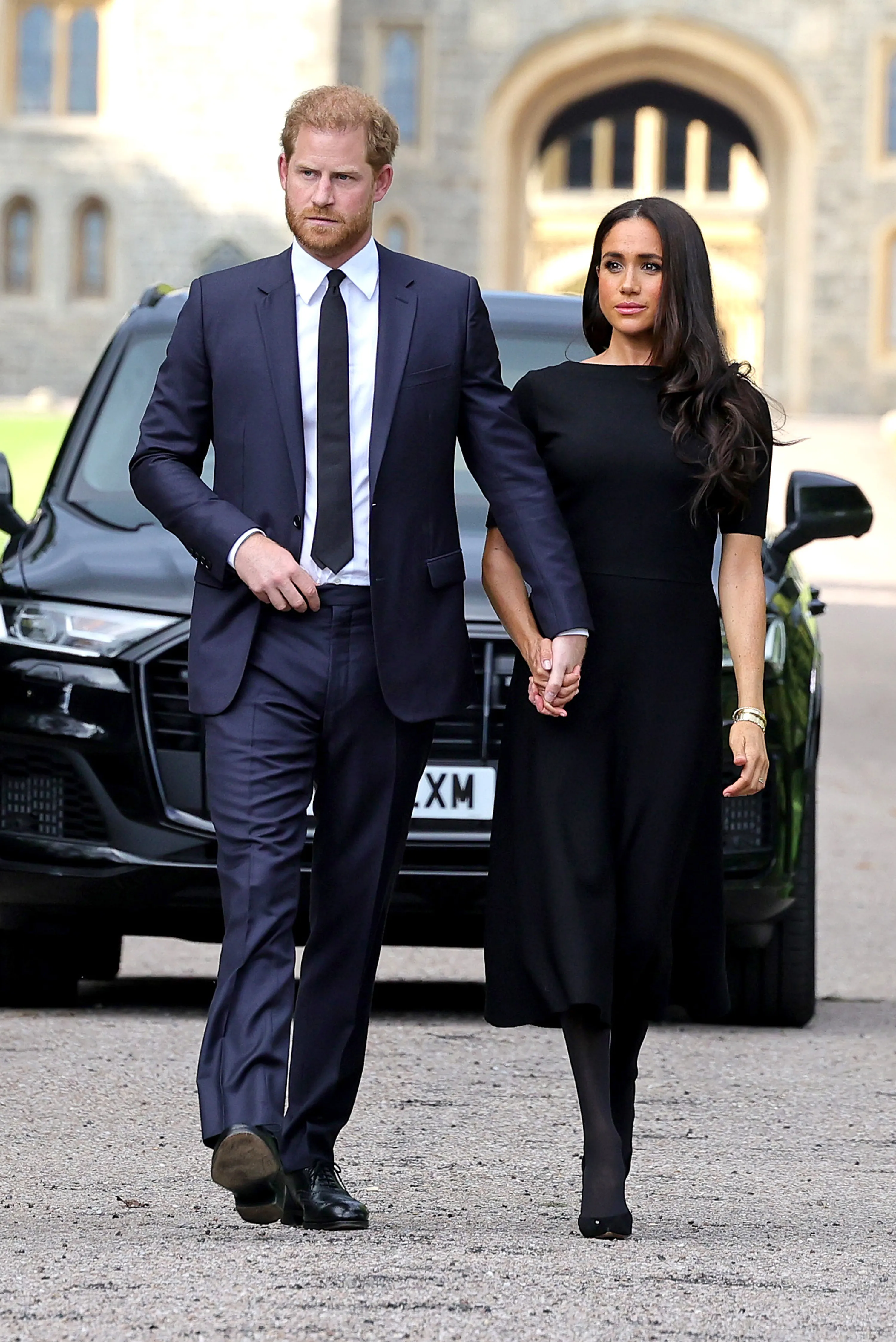 Prince Harry, Duke of Sussex, and Meghan, Duchess of Sussex walking together outside Windsor Castle.