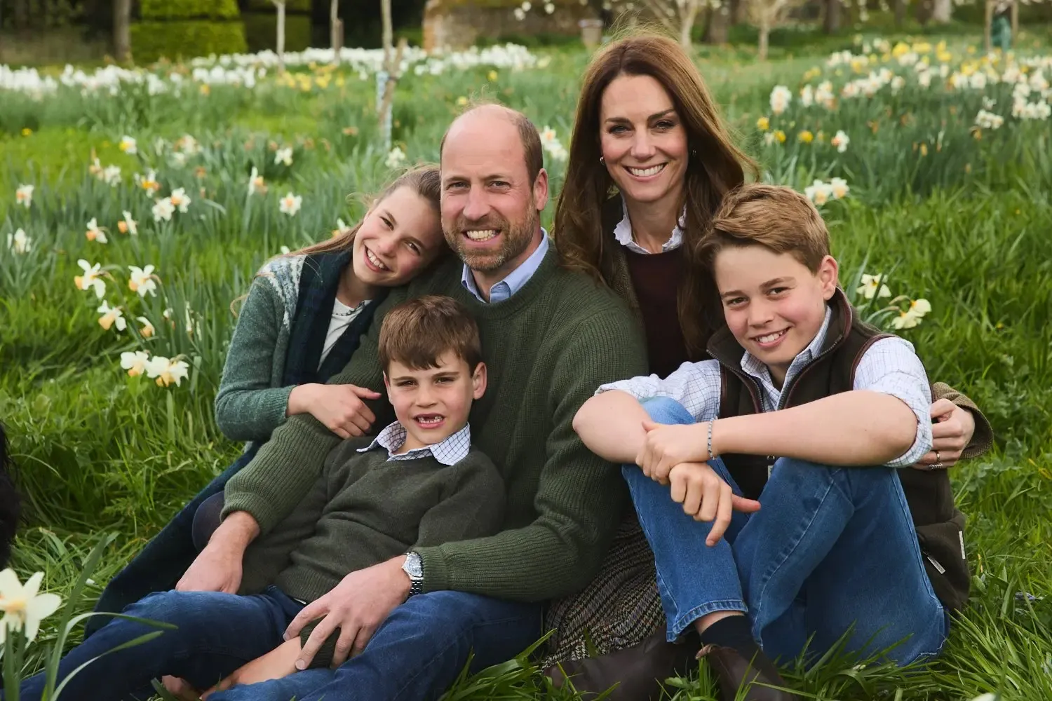 Prince William, Kate Middleton, Prince George, Princess Charlotte and Prince Louis posing together in a field of daffodils.