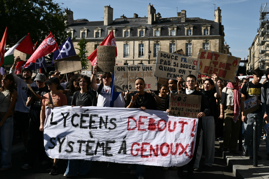 High-school students hold a large banner reading 