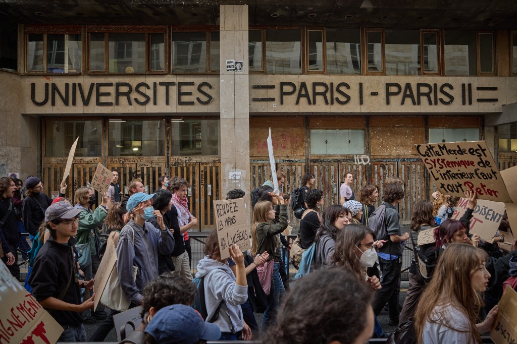 High-school students rally in front of the Universities Paris I and Paris II building, holding protest signs during a demonstration over learning conditions in Paris.