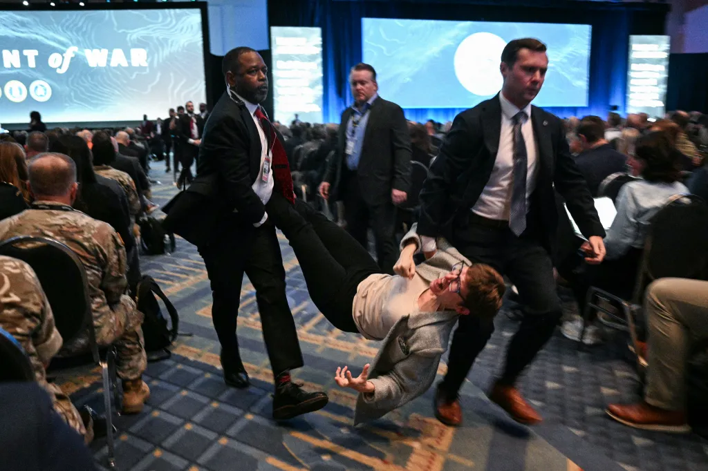 Security personnel remove a protestor from the Association of the United States Army Annual Meeting and Exposition.