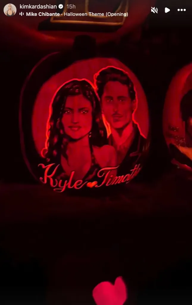 A carved pumpkin illuminated with a red glow, depicting a portrait of Kylie Jenner and Timothée Chalamet.