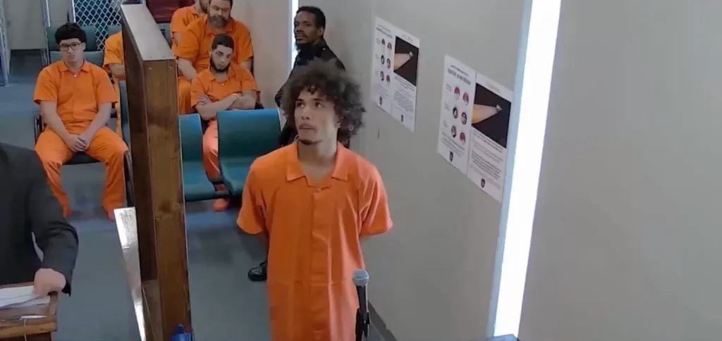 Quianelle Antonio Reyes-Cintron stands in a courtroom in an orange jumpsuit.
