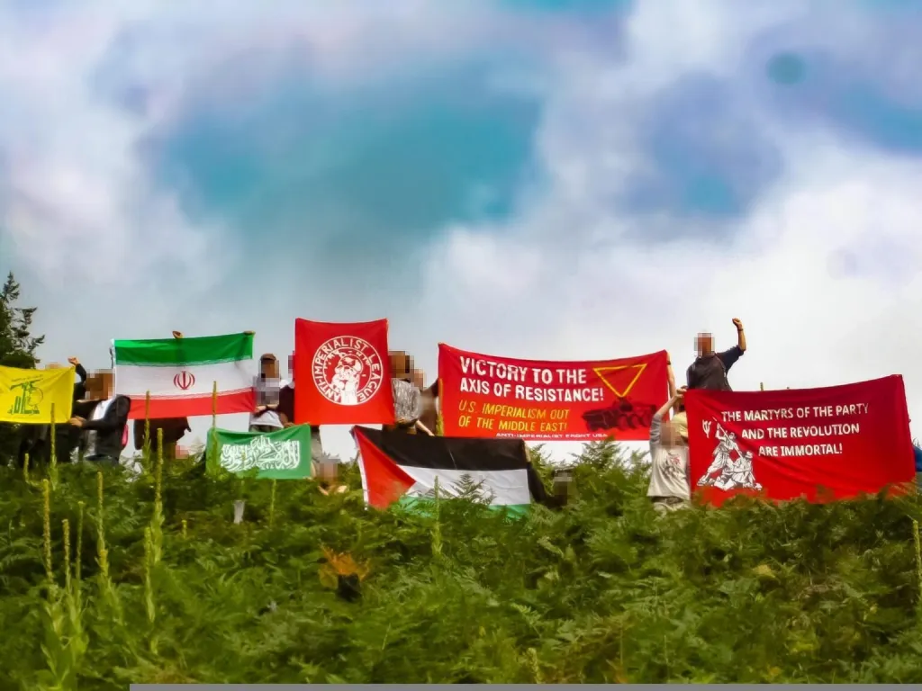 Attendees of the Anti-Imperialist Summer Camp hold flags and banners with slogans such as 