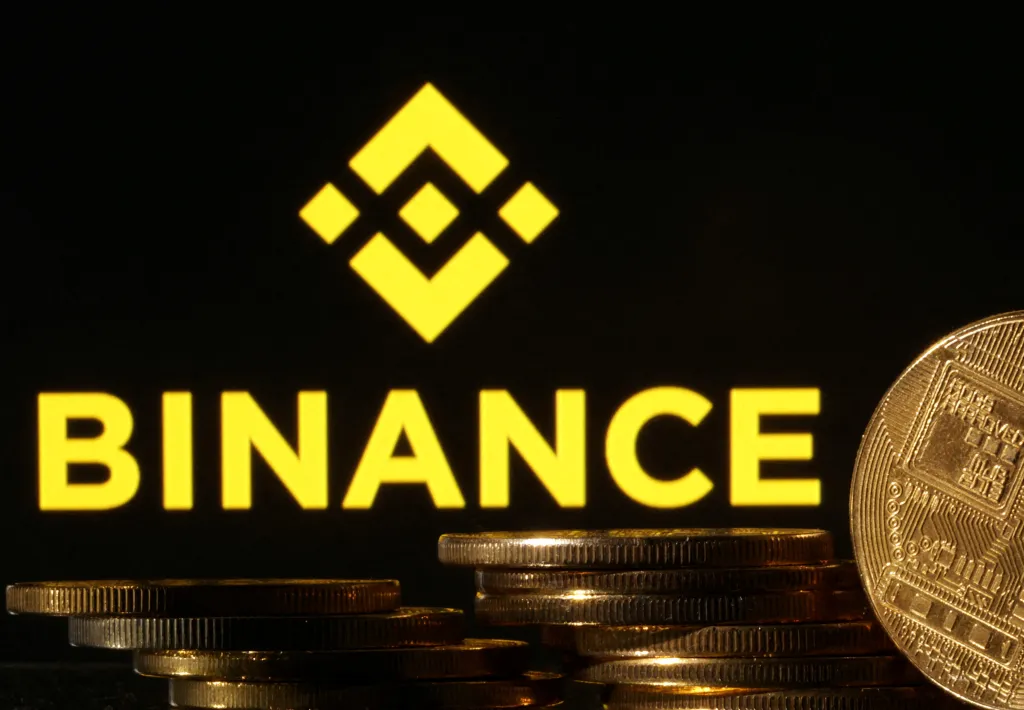 Illustration of cryptocurrency tokens in front of a Binance logo.
