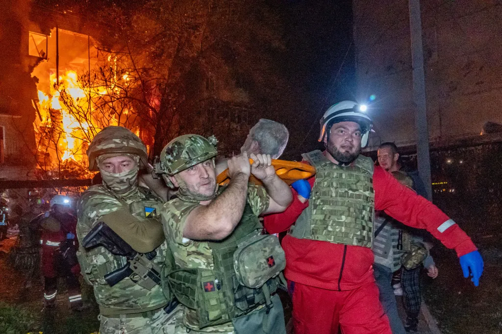 Rescuers evacuate an injured civilian after a residential building was hit following an air attack in Kharkiv, Ukraine.
