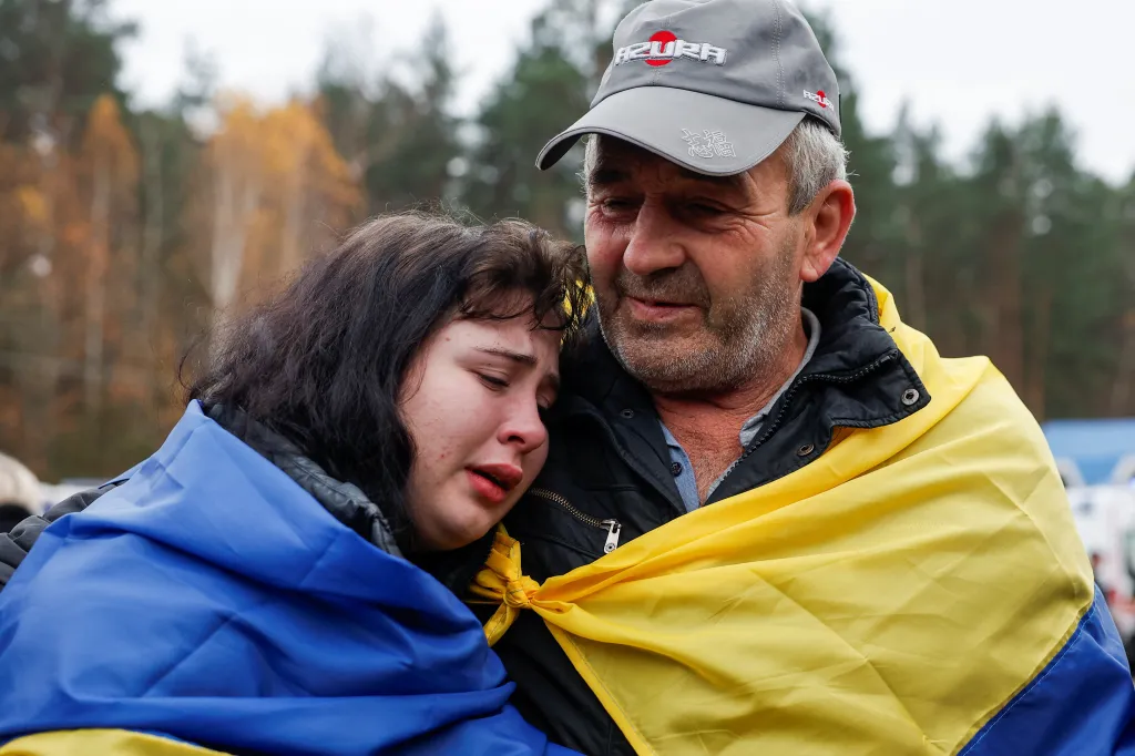 An evacuated resident from Oleshky hugs his daughter after returning to Ukrainian-controlled territory.