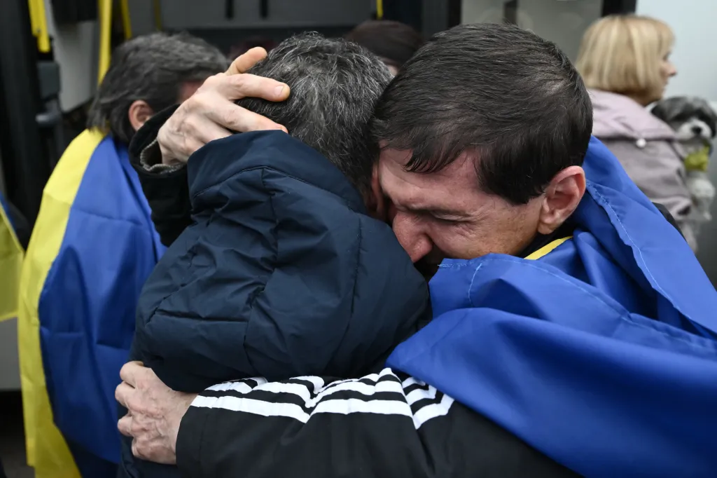 Evacuated residents embrace upon arriving at a safe location.