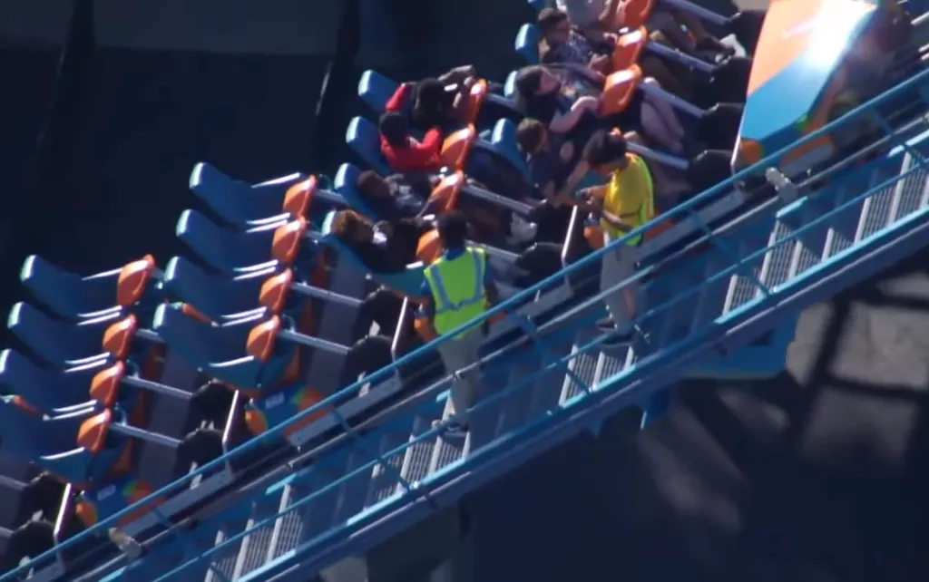 Riders are escorted off a Six Flags Over Georgia roller coaster due to an incident.