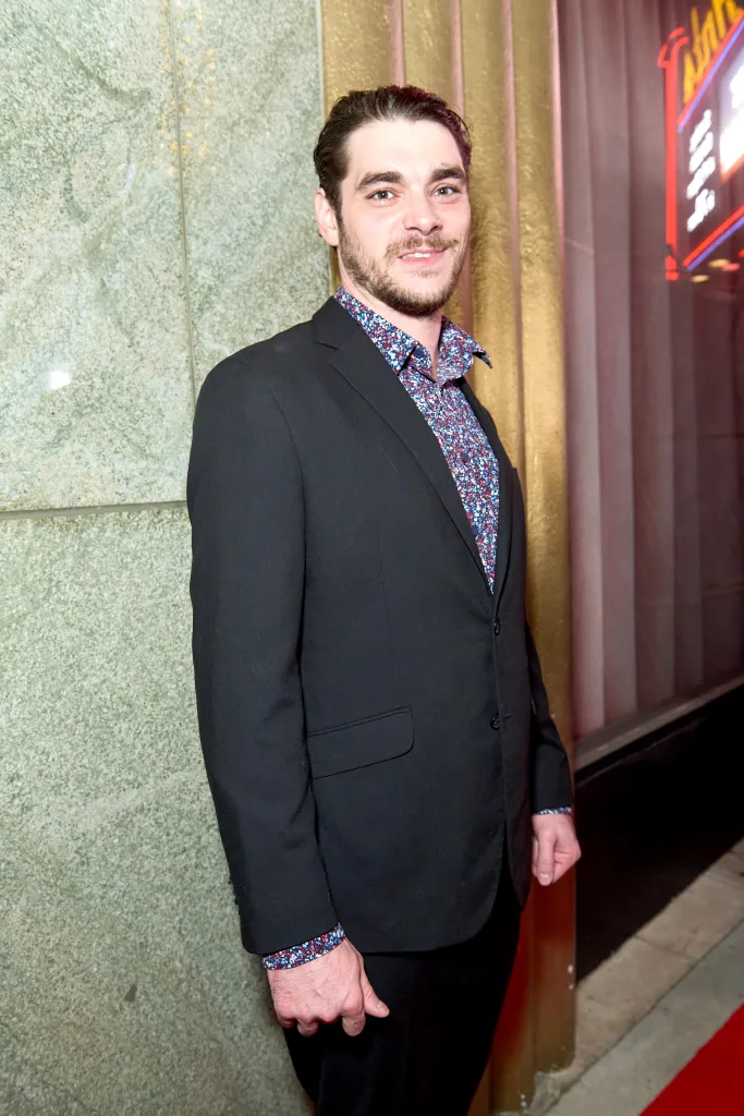 RJ Mitte wearing a black suit and a patterned shirt at a screening of 