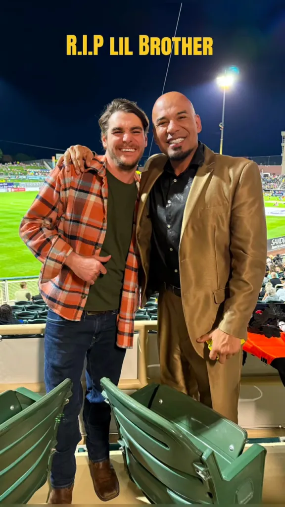 RJ Mitte and Luis Moncada smiling at a baseball game.