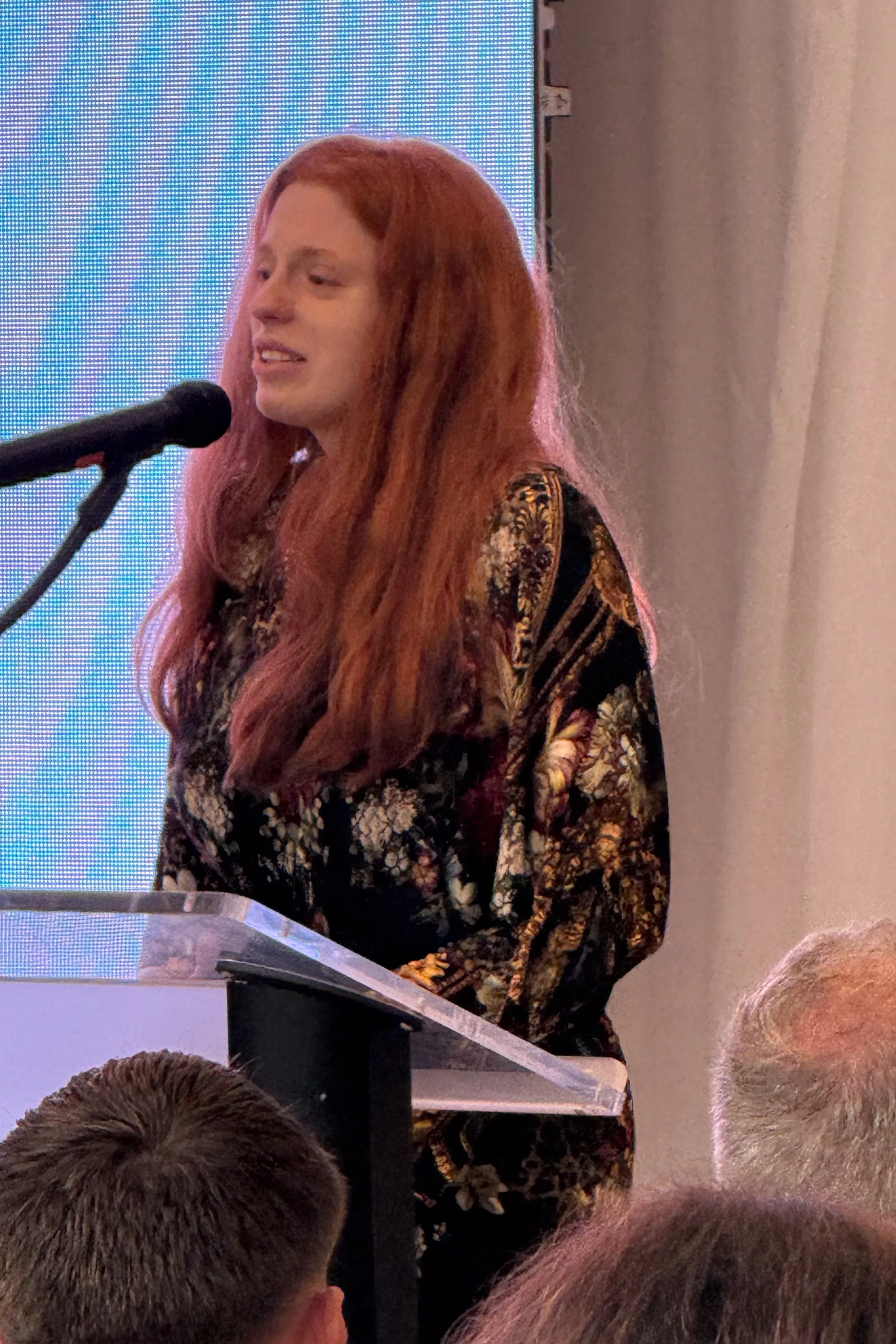 Lacianne Carriere speaks at a podium during a memorial event for her late brother.