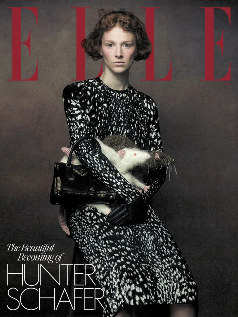 Hunter Schafer on the cover of ELLE magazine, wearing a black-and-white patterned dress and holding a black handbag and crocheted rat toys.