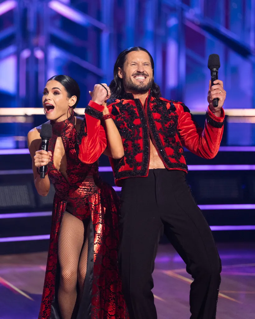 Jenna Dewan and Valentin Chmerkovskiy hold microphones and smile excitedly on a stage.