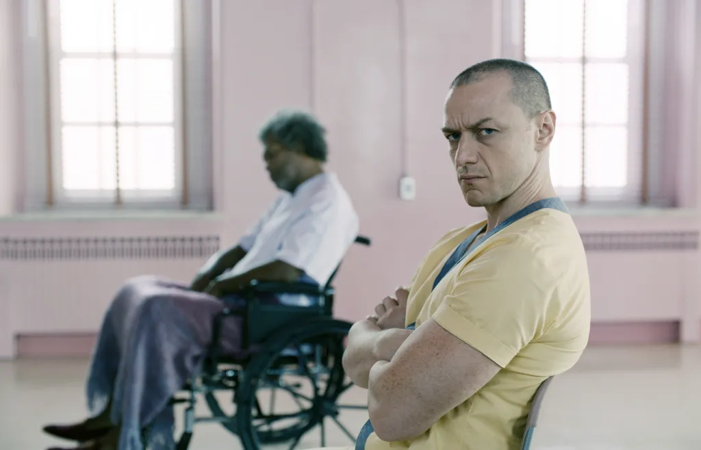 James McAvoy sits with his arms crossed while Samuel L. Jackson sits in a wheelchair in the background.