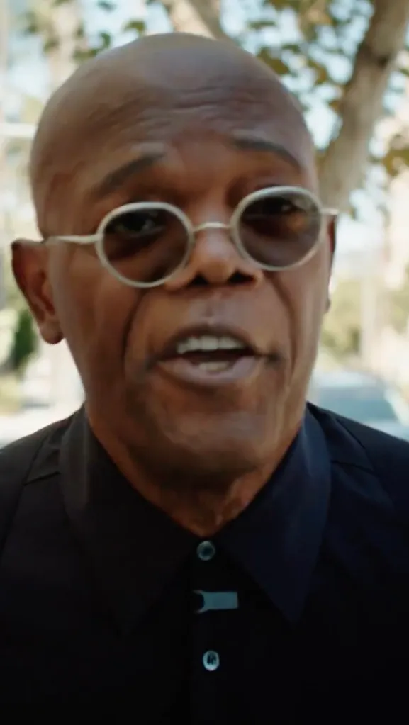 Samuel L. Jackson wearing round glasses and a black shirt outdoors.