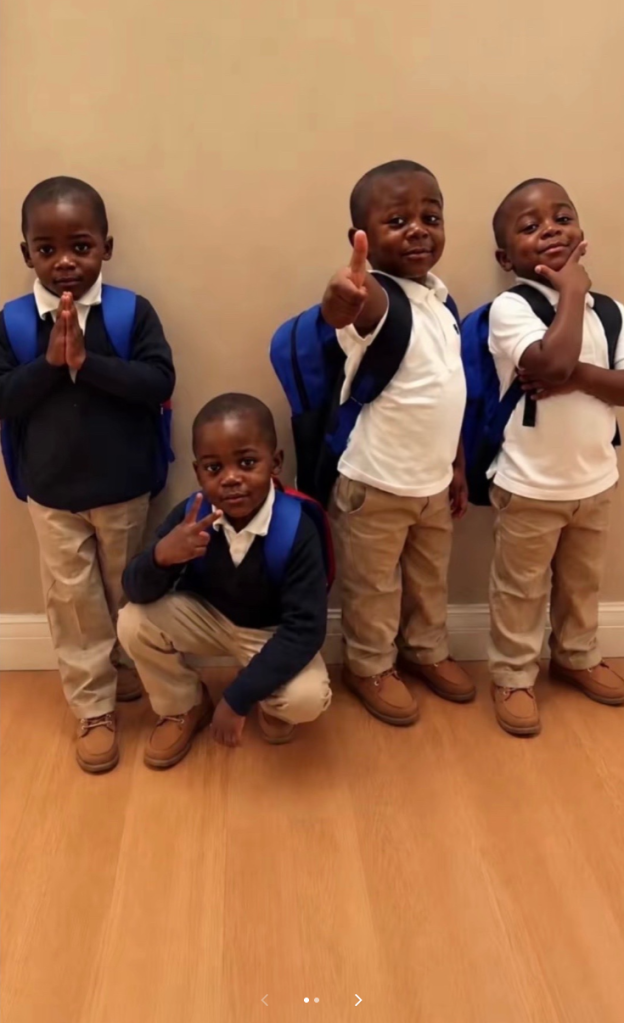 Four young boys wearing backpacks and school uniforms pose against a wall, making different gestures.