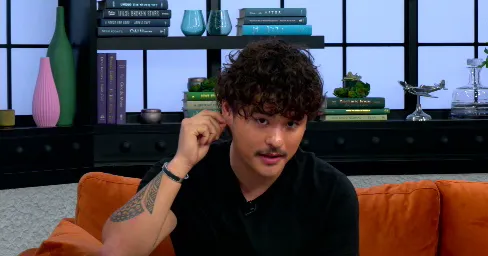 Collin Gosselin sits on an orange couch during an interview.