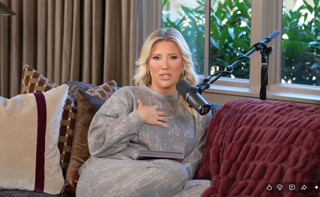 Savannah Chrisley sitting on a couch with a microphone in front of her.