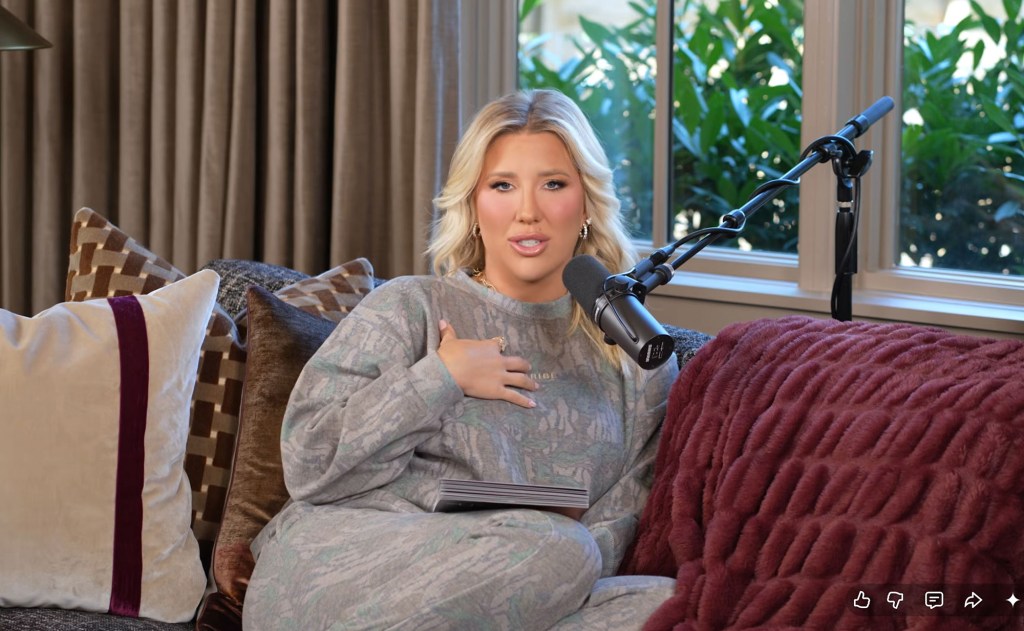 Savannah Chrisley sitting on a couch with a microphone in front of her.