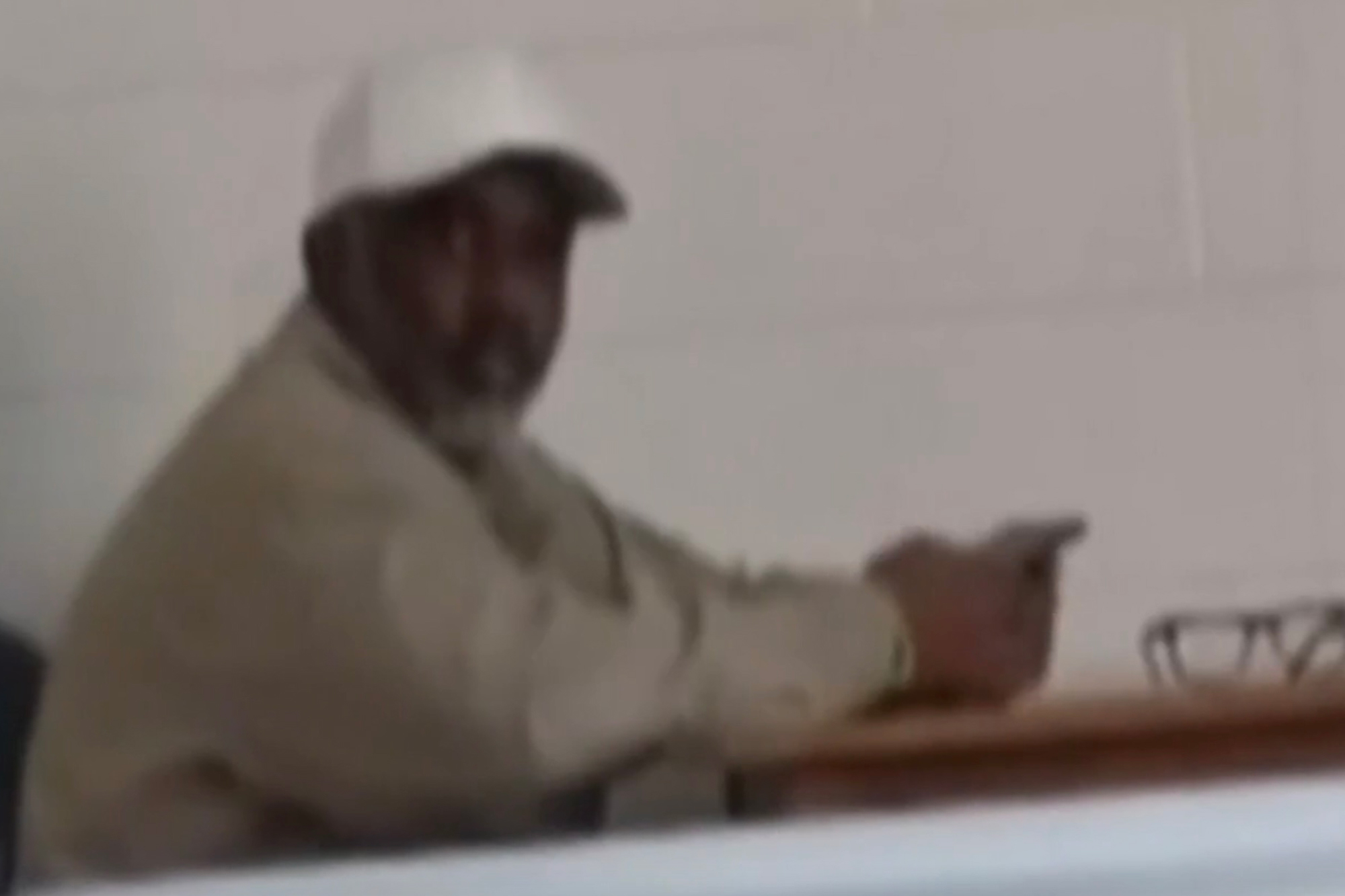 Sean Combs wearing a white hat and sitting at a desk.