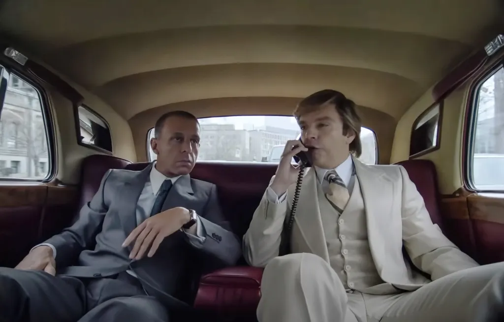 Sebastian Stan as Donald Trump and Jeremy Strong as Roy Cohn in the back of a car.