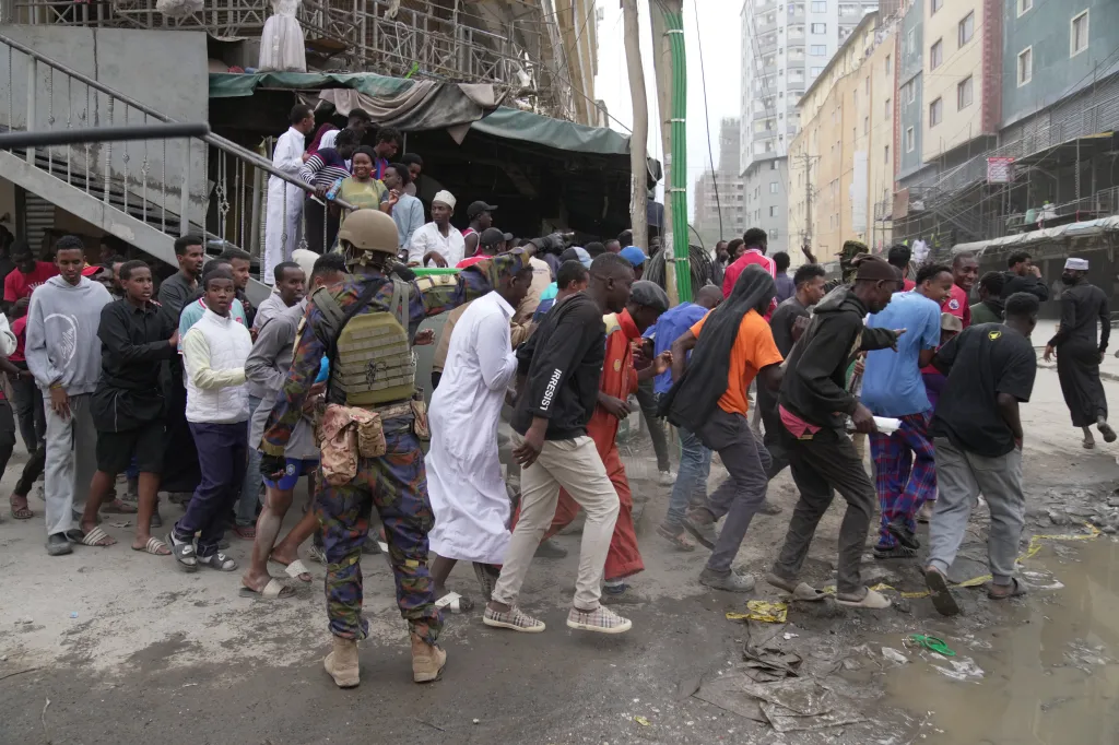 Security forces chase people away from the scene of a multi-story building that collapsed in Nairobi, Kenya.