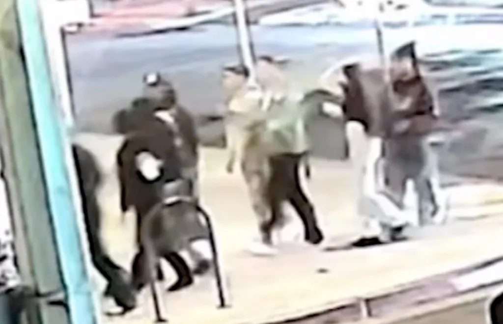 Security camera footage shows a group of people arguing on a sidewalk.