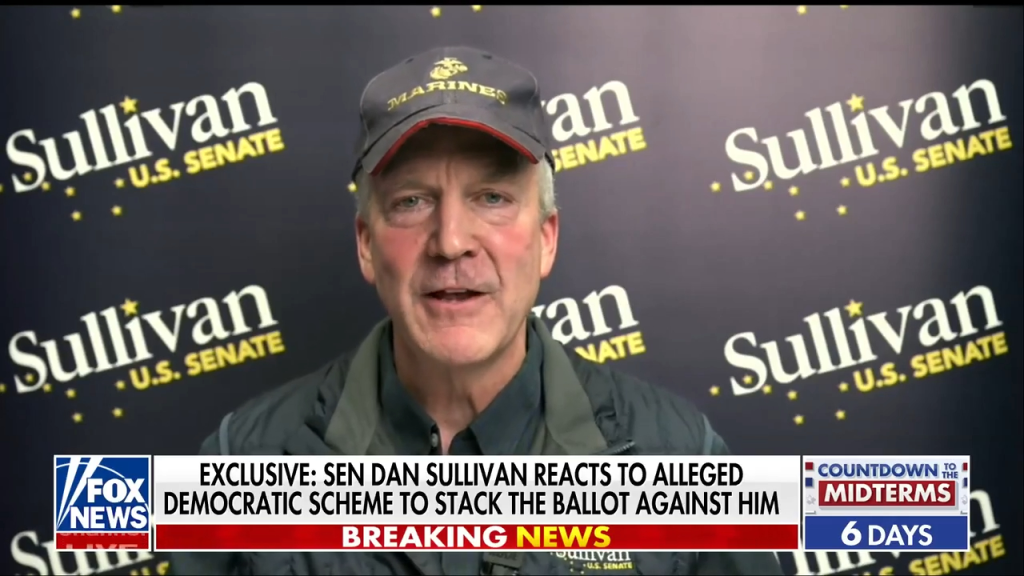 Senator Dan Sullivan speaking in front of a backdrop with his name.
