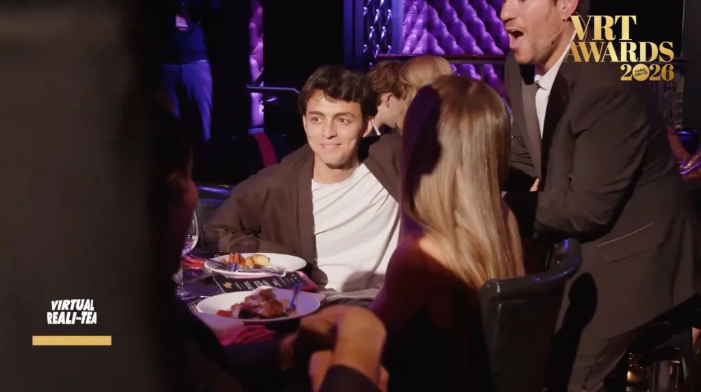 Shai Fruchter smiles while sitting at a table with other guests at the VRT Awards.